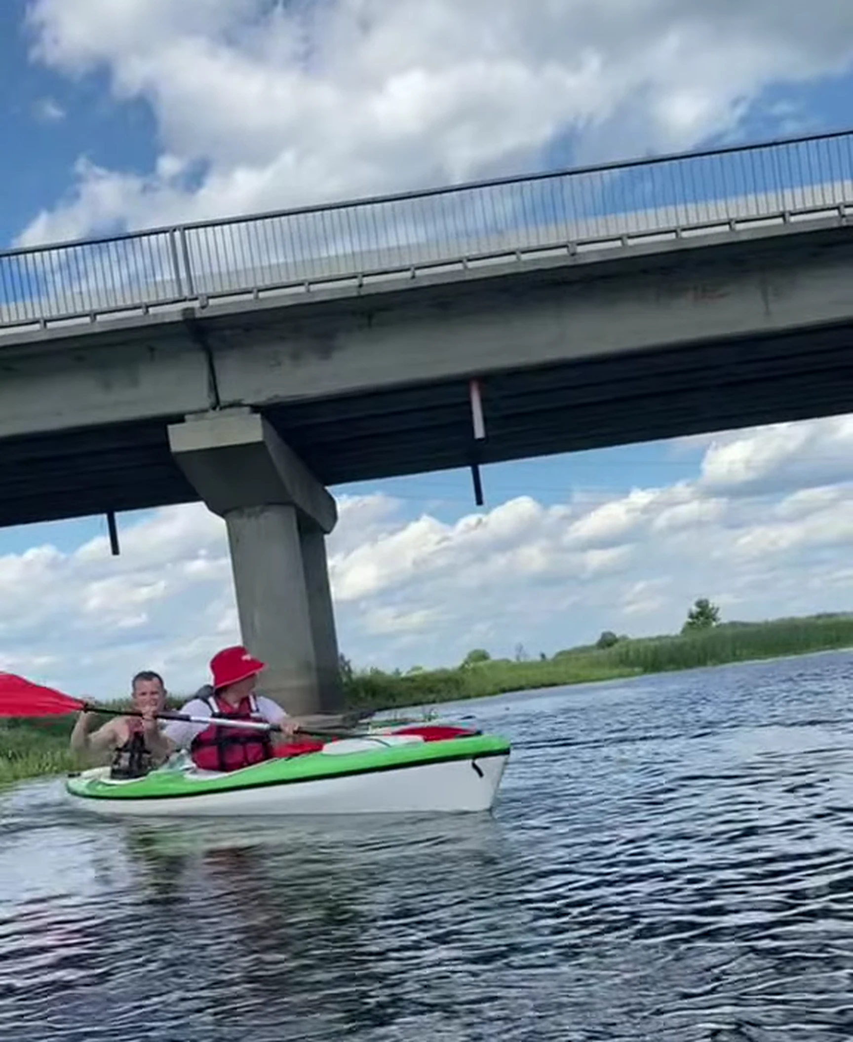 Kayakers passing beneath a bridge